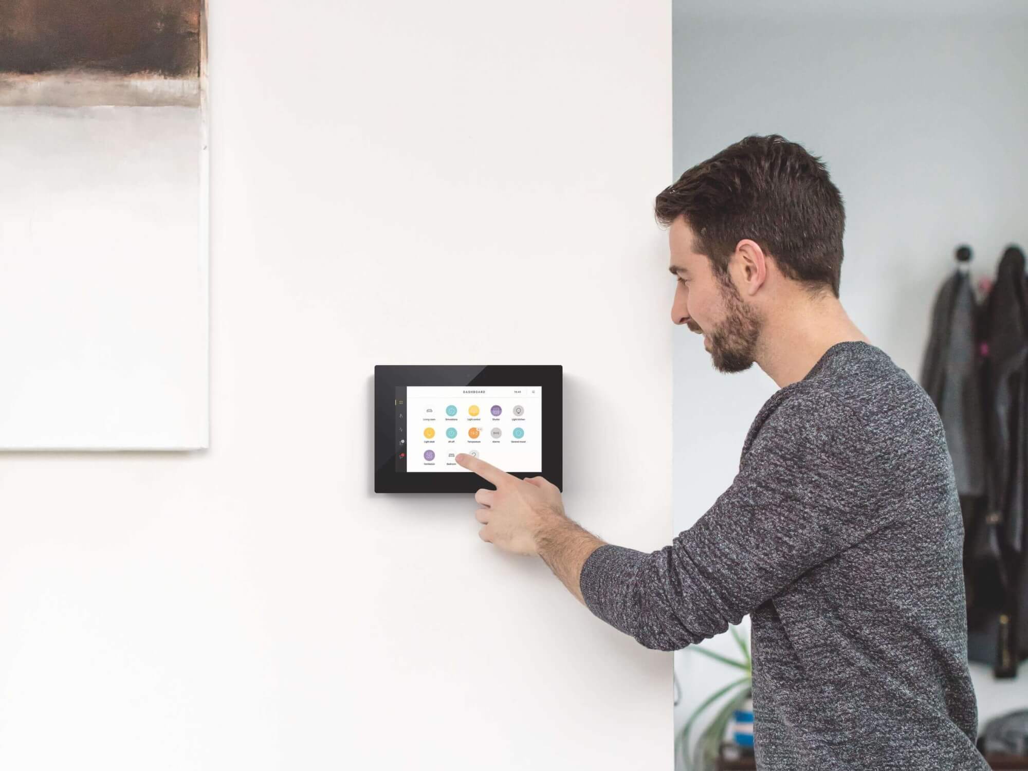Mann bedient Niko Home Control über den Touchscreen